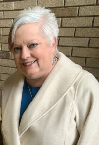 A white-presenting woman with short white hair